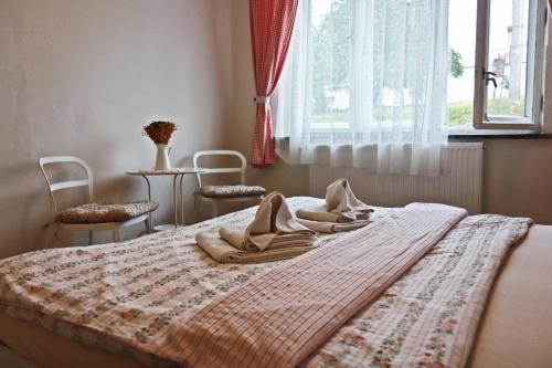 uma cama com um cobertor e duas cadeiras num quarto em Ubytování Ledňáček em Lednice