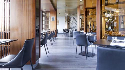 un restaurant avec des chaises et des tables et un bar dans l'établissement La Voile Rouge, à Rosporden