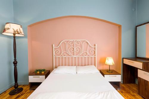 a bedroom with a white bed with a large headboard at Cheers Midtown Hostel in Istanbul