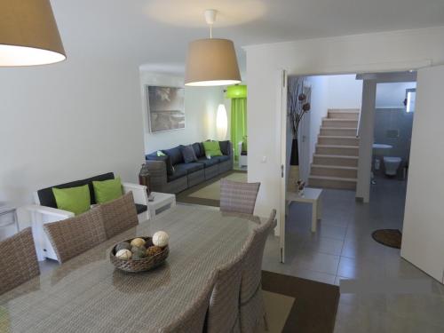 een woonkamer en eetkamer met een tafel en stoelen bij Villa de vacances 3 chambres et 6 couchages max. à proximité de mer à Praia Verde Algarve in Monte Gordo