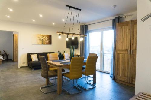 ein Esszimmer und ein Wohnzimmer mit einem Tisch und Stühlen in der Unterkunft Wohnung 2 im Kirschblütenhof in Ingelheim am Rhein
