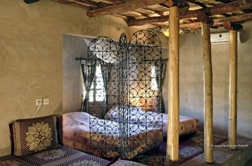 ein Eisenbett in einem Zimmer mit Fenster in der Unterkunft Les Terrasses de l'Atlas in Imoulass