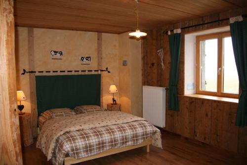 a bedroom with a bed with a green headboard at La Fée Verte in Arc-sous-Cicon