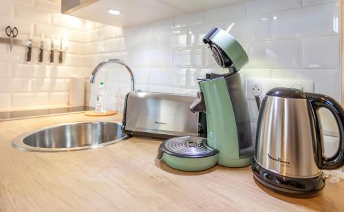 - un comptoir de cuisine avec un mixeur et un évier dans l'établissement Le Petit Versailles, à Versailles