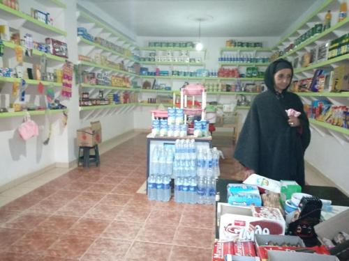 a woman is standing in a store aisle at Auberge oued dades in Boumalne