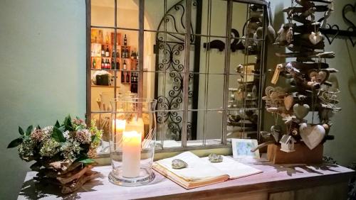 un tavolo con una candela, libri e uno specchio di Locanda di Mirandolina a Tuscania
