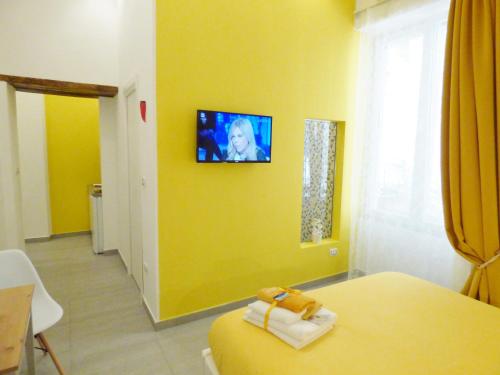 een kamer met een bed en een tv aan de muur bij B&B Lemon Flats in Napels