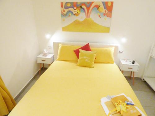 een slaapkamer met een groot bed met gele en rode kussens bij B&B Lemon Flats in Napels