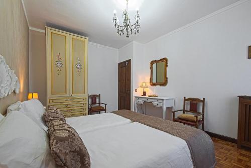 a bedroom with a bed and a desk and a mirror at VECCHIA FAVOLA HOUSE in Quarto dʼAltino