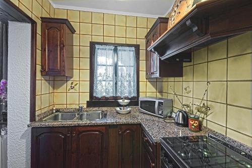 a kitchen with a sink and a stove and a window at VECCHIA FAVOLA HOUSE in Quarto dʼAltino