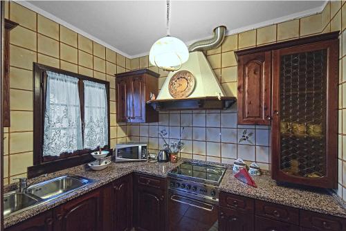una cucina con lavandino e piano cottura forno superiore di VECCHIA FAVOLA HOUSE a Quarto dʼAltino