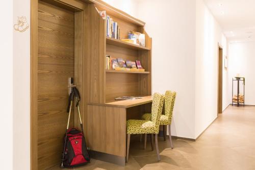 a room with a desk and two chairs and a backpack at Astor Hotel in Schenna