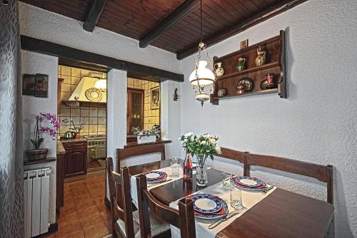 a kitchen and dining room with a table and chairs at VECCHIA FAVOLA HOUSE in Quarto dʼAltino