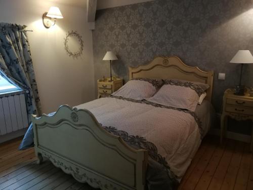 een slaapkamer met een bed, 2 lampen en een raam bij Le Dauphin in Chabeuil