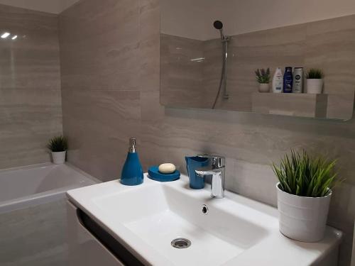 a bathroom with a white sink and a bath tub at Brand new apartment in Rebreanu Towers Residence in Timişoara