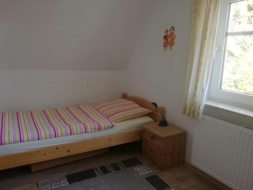 uma pequena cama num quarto com uma janela em Ferienhaus Moorhof em Schneverdingen