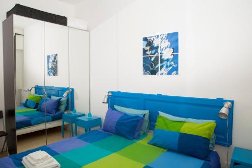 1 dormitorio con cama azul y espejo en LA PAUSA en Roma