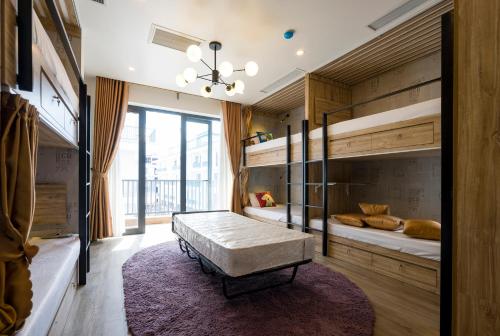 a bedroom with two bunk beds and a large window at BBQ HOSTEL in Ha Long