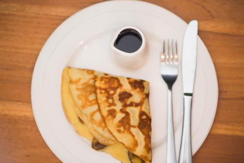 a white plate with a slice of pizza on it at Suntari Homestay in Ubud