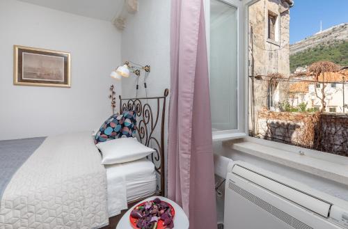 a bedroom with a bed and a window with a view at Booba Rooms in Dubrovnik