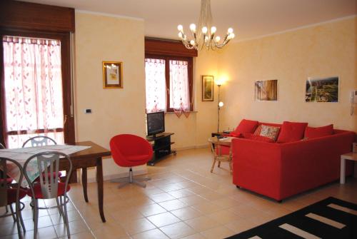 a living room with a red couch and a table at B&BLeTerrazze BoutiqueHotel2-Torino in Ciriè