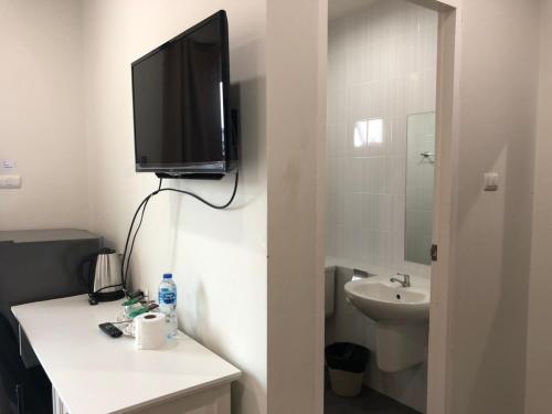 a bathroom with a tv on the wall and a sink at Khao Oat airport in Nai Yang Beach