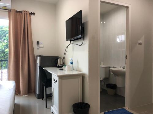 a room with a desk with a television and a bathroom at Khao Oat airport in Nai Yang Beach
