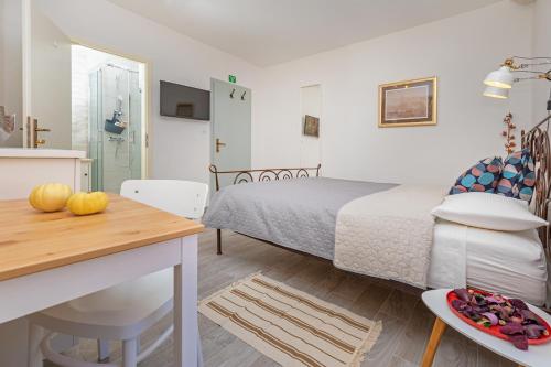a bedroom with a bed and a table and a kitchen at Booba Rooms in Dubrovnik
