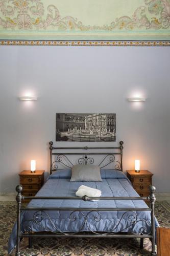 a bedroom with a blue bed with two night stands at Antica Dimora in Palermo