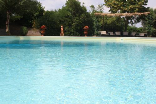 a large pool of blue water with trees in the background at Agriturismo Materno in Radicondoli