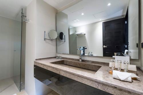 baño con lavabo grande y espejo en Movich Casa del Alferez, en Cali
