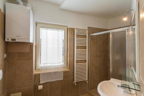 bagno con servizi igienici, lavandino e finestra di Appartamento di Bianca C. ad Assisi