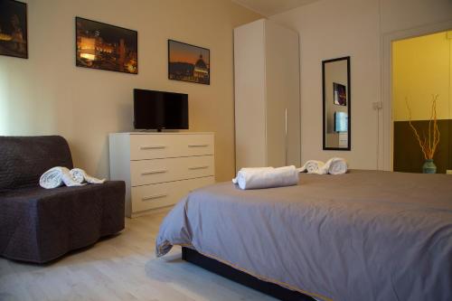 sypialnia z łóżkiem, telewizorem i krzesłem w obiekcie San Silverio Luxury House w Rzymie