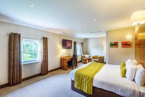 a hotel room with a bed and a desk at Owston Hall Hotel in Doncaster