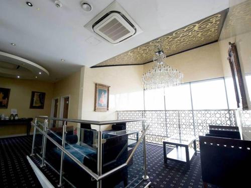 a dining room with a chandelier and a table at Ramada Birmingham Oldbury M5 J2 in Oldbury