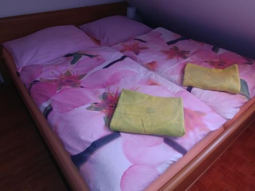 un letto con fiori e due cuscini di Podkroví - ubytování Brdy a Bohutín