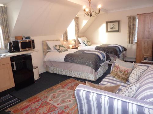 a hotel room with two beds and a couch at Maunditts House in Malmesbury