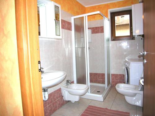 łazienka z 2 toaletami, umywalką i prysznicem w obiekcie Casa Mary w mieście San Siro
