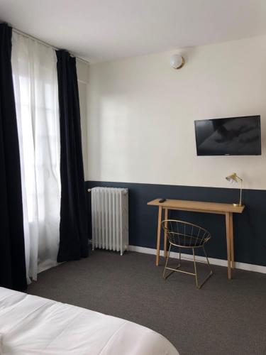 a room with a bed and a desk and a window at Hotel Saint Louis in Brest