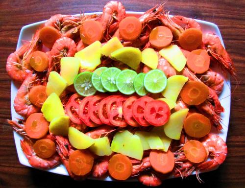 a tray of shrimp and vegetables on a table at Tamara Motels in Hikkaduwa
