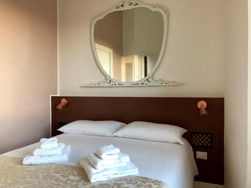a bedroom with a bed with a large mirror at B&B Dimor'à in Pitigliano