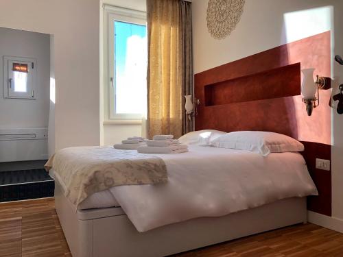 a bedroom with a large bed with towels on it at B&B Dimor'à in Pitigliano