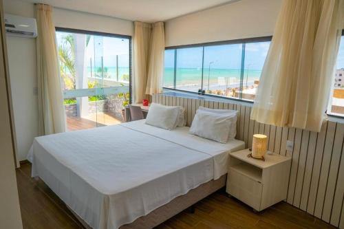 sypialnia z łóżkiem i widokiem na ocean w obiekcie Bessa Golden Flats w mieście João Pessoa