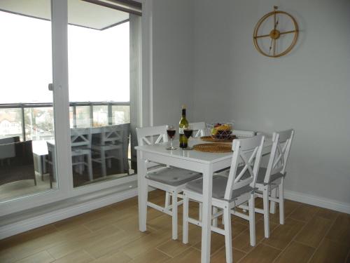 biały stół jadalny z krzesłami i oknem w obiekcie LIRA Apartament w Gdańsku