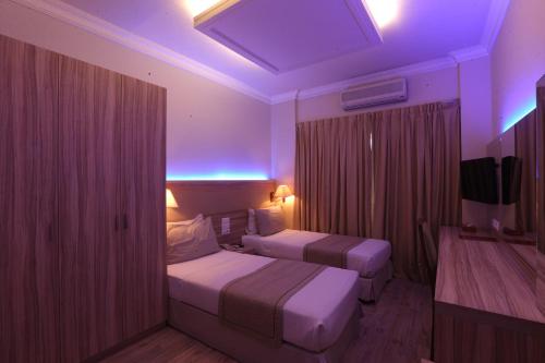 a hotel room with two beds and a purple lighting at Padova Hotel in Beirut