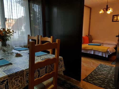 a dining room with a table and chairs and a bedroom at Nena & Rale Rooms in Donji Milanovac