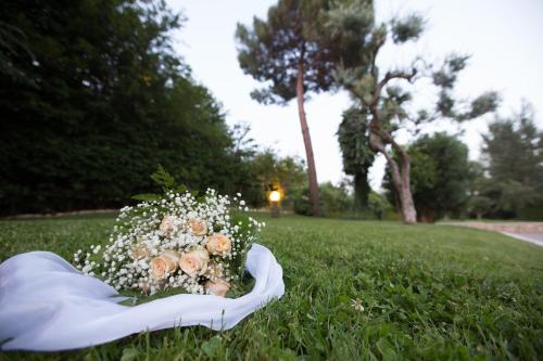a bride holding a bouquet of flowers in the grass at Yellow Park Hotel in Forchia