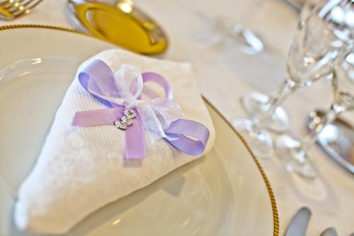 a napkin with a purple bow on a plate at Yellow Park Hotel in Forchia