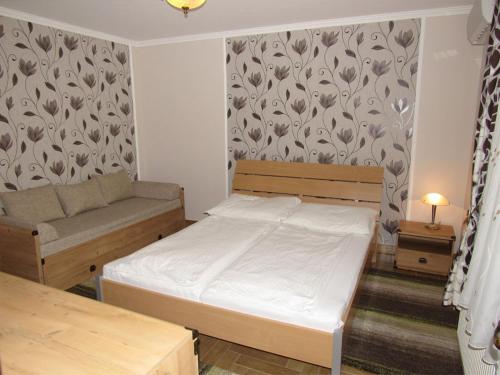 A bed or beds in a room at Szegfű Apartman