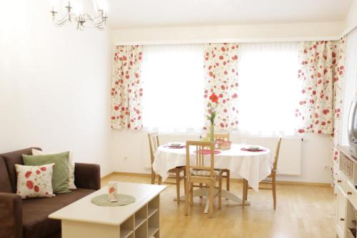 a living room with a table and two windows at Hotel-Restaurant Liebnitzmühle in Raabs an der Thaya